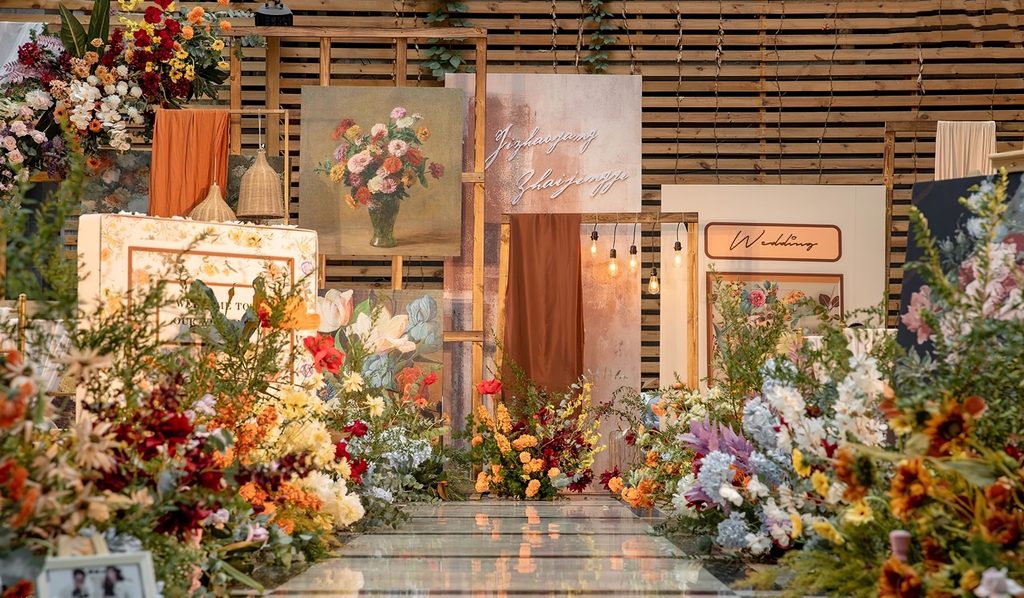 原木格栅、花卉油画、橙色布幔与彩色花艺组成的婚礼主背景